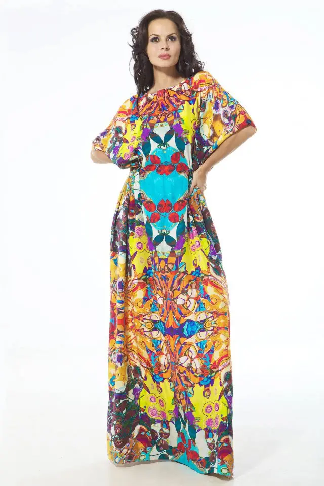 This Designer kaftan merges two distinct prints from the collection into one fluid silhouette. The upper half features a gold-toned spiral motif, creating a decorative, luminous surface that extends to the waist. From there, the garment transitions into a gathered and draped skirt in a grey and white camouflage-inspired pattern, originally seen in a jumpsuit form earlier in the series. The contrast between the ornamental top and muted, graphic lower half gives the piece depth and movement, while the gathering at the waist provides shape. This look reflects Resort 2013’s recurring theme of print layering and visual contrast, drawing on multiple design elements to create a unified, wearable form.